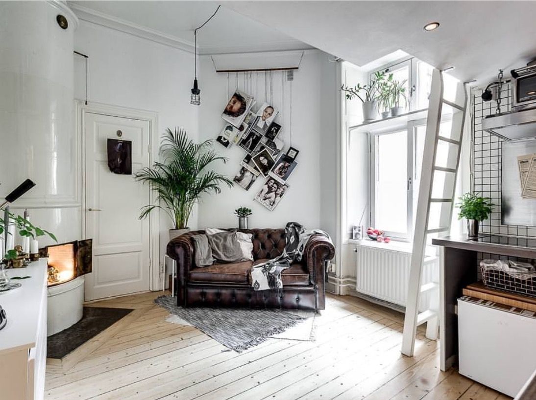 small dark leather chesterfield sofa in loft apartment