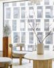 Living room in an apartment in a high-rise building with white modern furniture and naturala ccents