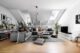 Gray living room with plants in corners and the window sill